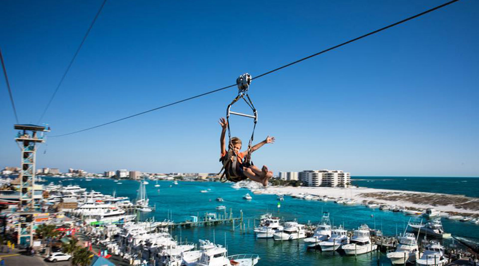 Zipline over marina with yachts and coastal views